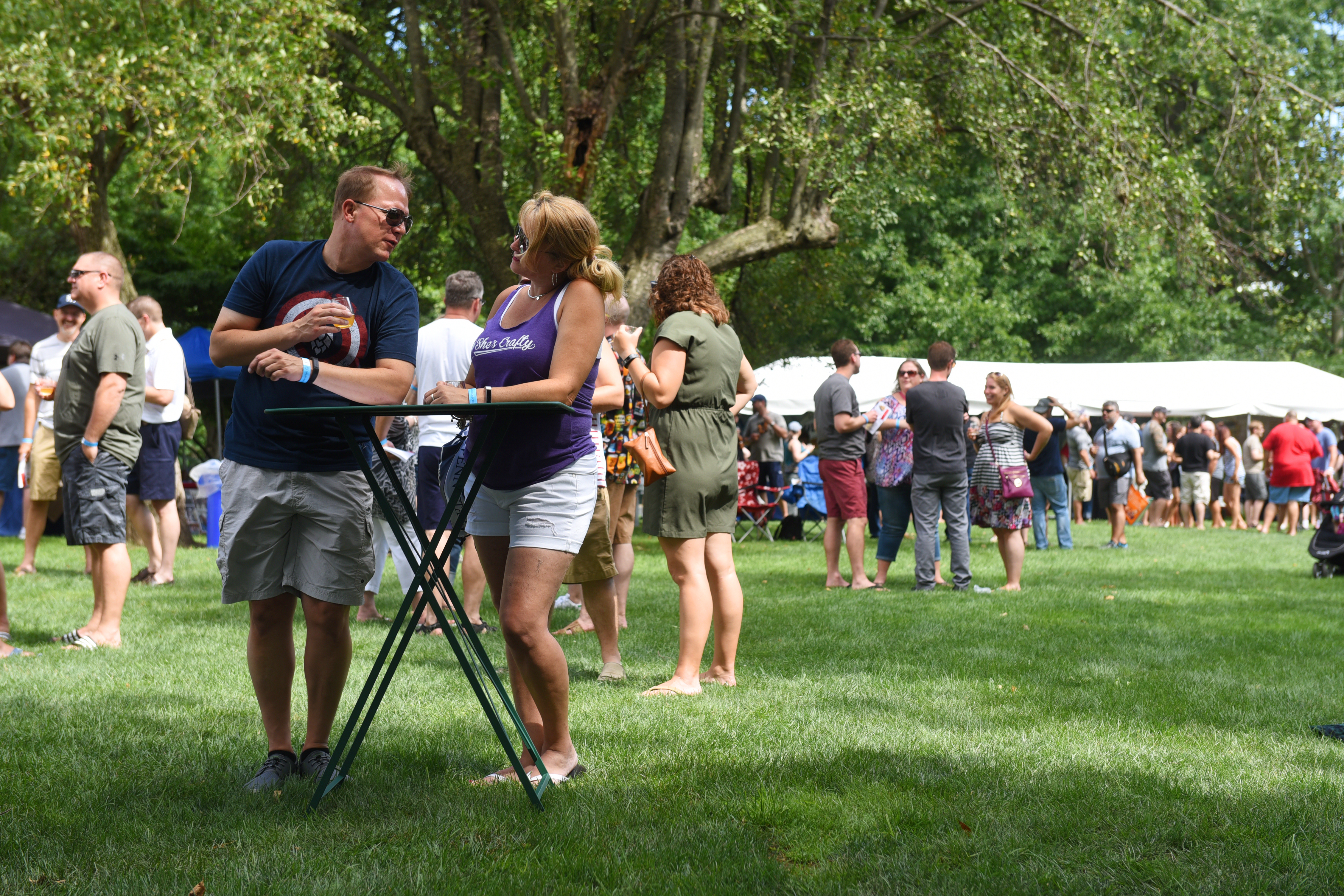 A couple at a table in the park surrounded by other groups of people