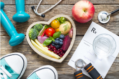 Healthy Fruits in a heart-shaped bowl, hand weights, sneakers, apple, stethoscope and Rx to eat fruit and vegetables