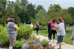 instructors and students admiring flowers