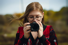 Teenage girl holding a digital camera